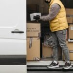 Deliveryman arranging packages in white van for efficient distribution.